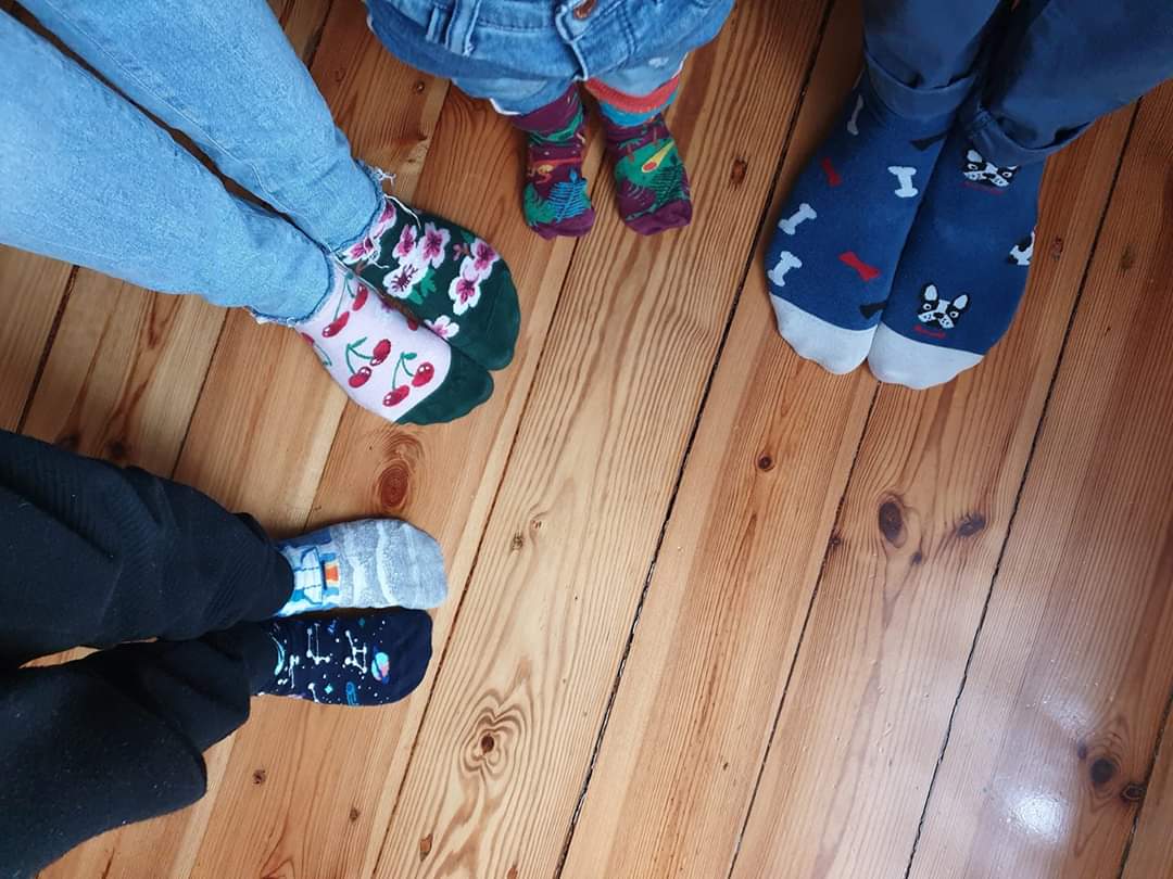 Na zdjęciu stopy czworga dzieci. Każde z nich ma dwie różne skarpetki z okazji Światowego Dnia Zespołu Downa. 