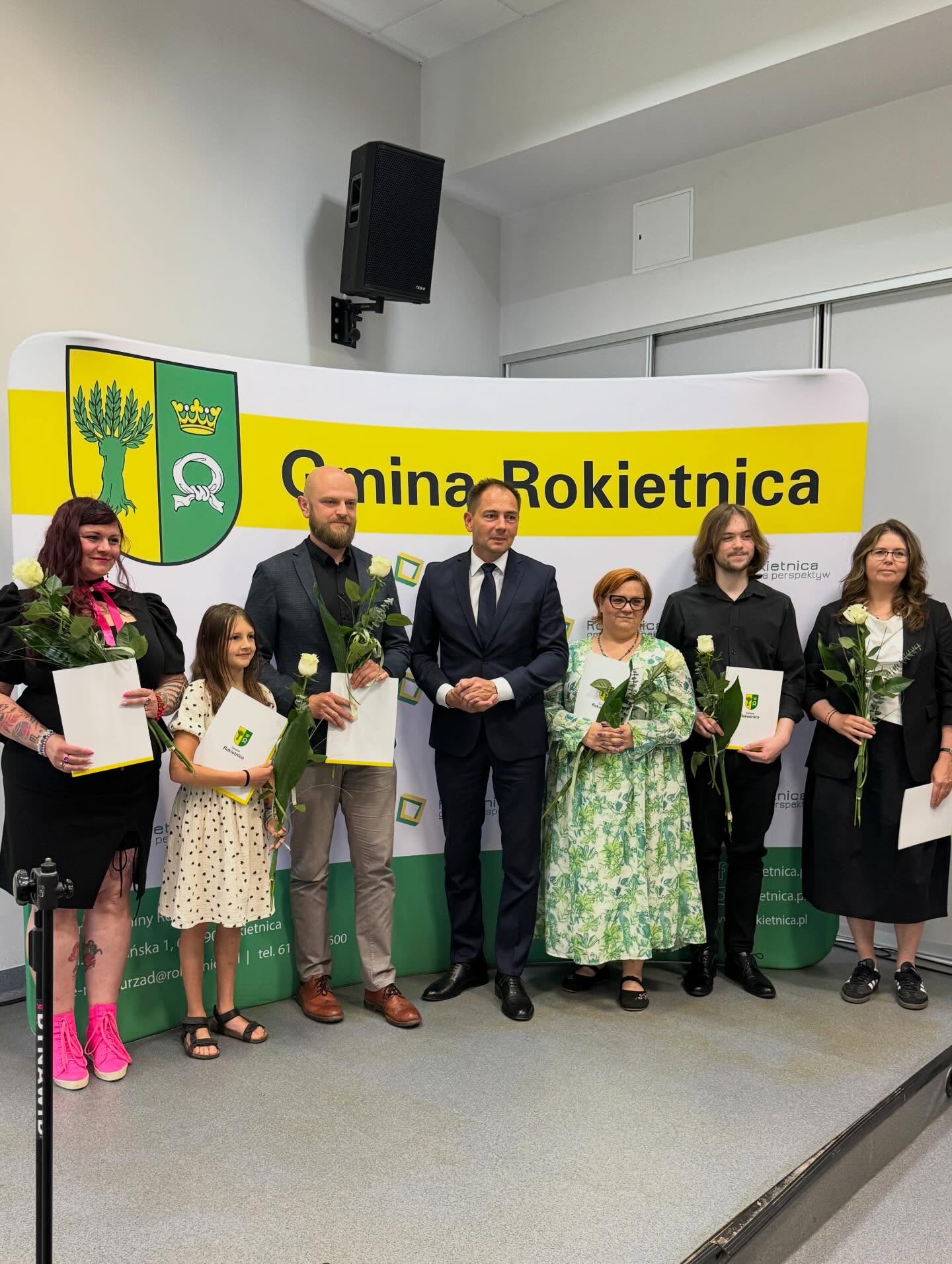 Ścianka Gminy Rokietnica, W&oacute;jt Gminy Rokietnica, i&nbsp;uczestnicy konkursu wraz z&nbsp;dyplomami i&nbsp;kwiatami. 