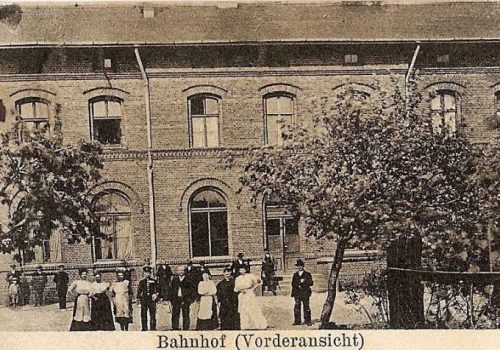 Czarno-białe zdjęcie pokazujące budynek dworca w&nbsp;Rokietnicy z&nbsp;poniższym napisem: Bahnhof (Vorderansicht)
