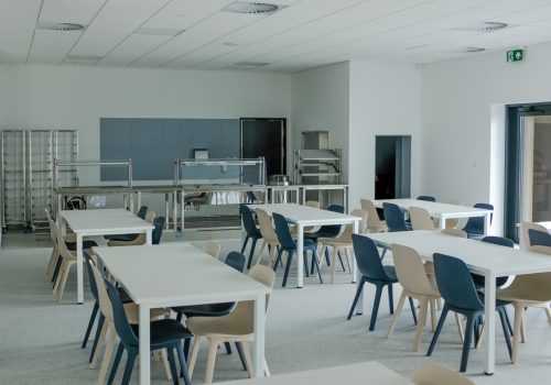 Na zdjęciu wnętrze klasy w szkole podstawowej w Cerekwicy, a w niej białe stoliki, granatowe i beżowe krzesła oraz regały. Fot. Damian Nowicki